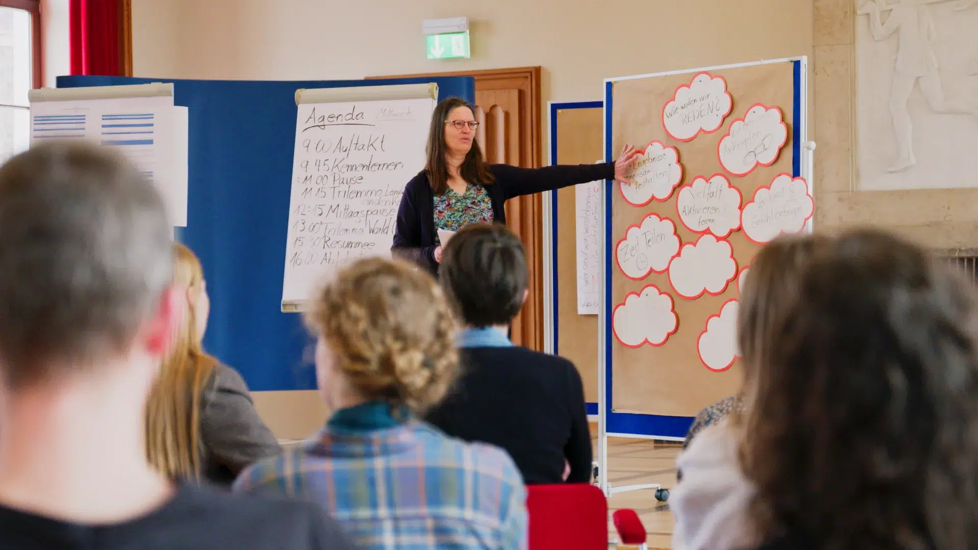 Moderatorin des Fraunhofer ISI erläutert Agenda und Gesprächsregeln der Zukunftswerkstatt Landwende vor Flipchart und Pinnwand