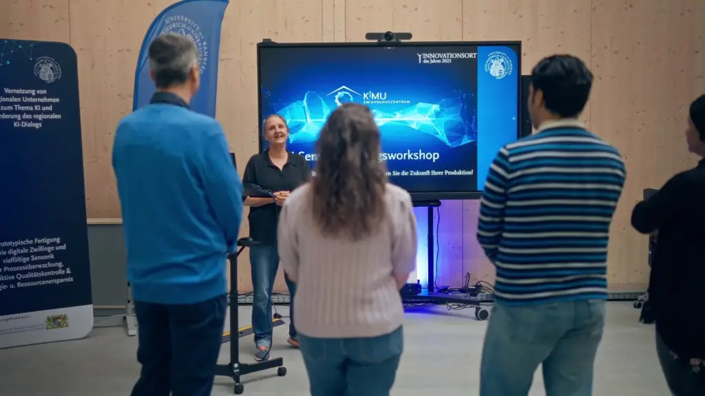 Ute Schmid präsentiert im KMU-KI-Erfahrungszentrum, ausgezeichnet als Innovationsort des Jahres 2025; Szene aus dem Porträtfilm über die Communicator-Preisträgerin Prof. Dr. Ute Schmid für die DFG. Produziert von Sterntaucher Filmproduktion.